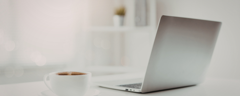 ordinateur sur un bureau avec une tasse de café utilisé pour travailler sur un ebook MRR