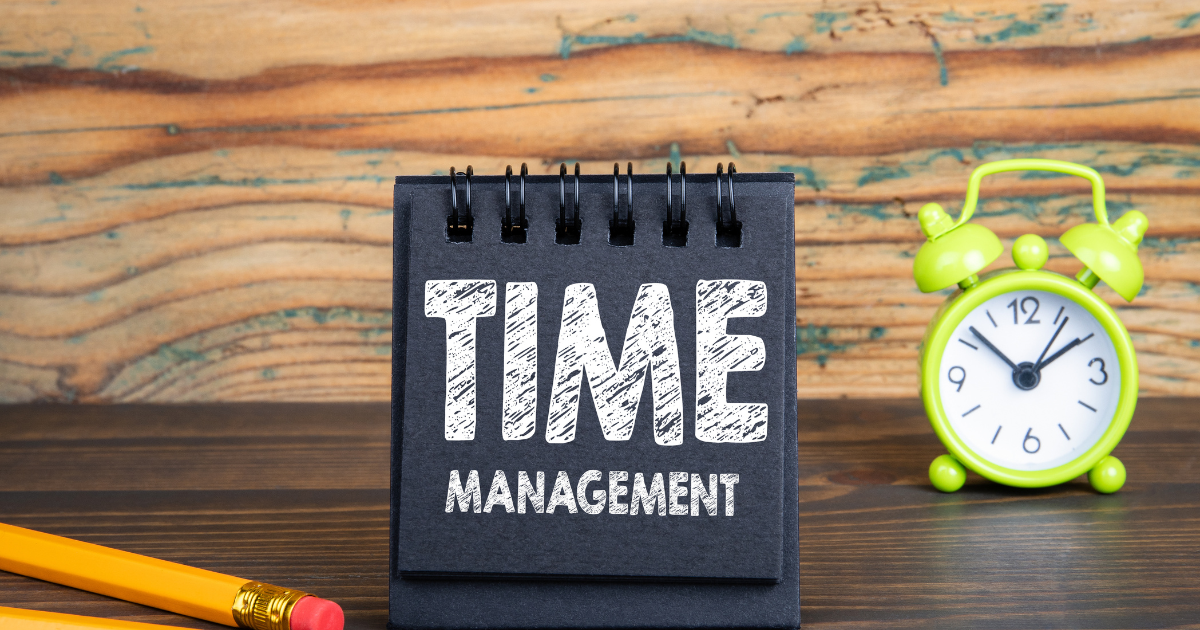 Bloc-note avec l’expression time management et un réveil, illustrant la gestion du temps pour maman aidante