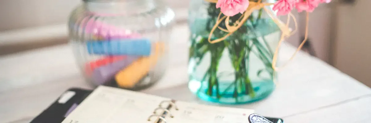 Outils pratiques pour s’organiser et créer, bureau avec carnet ouvert pour noter les tâches.