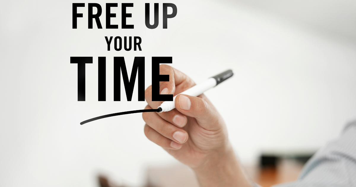main écrivant sur un tableau noir "free up your time", symbolisant l'optimisation du temps libre pour une activité digitale rentable de maman aidante.