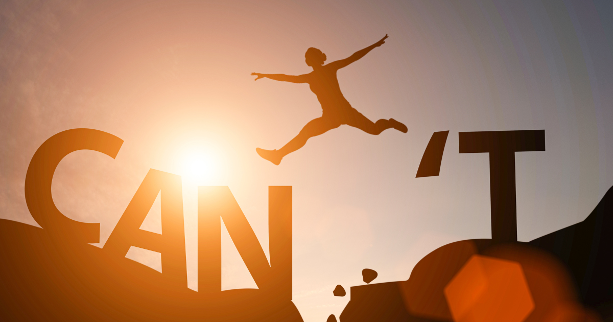 Mindset entrepreneurial : une personne prend son courage à deux mains et saute d’un rocher à un autre, brisant sa peur et ses croyances limitantes.